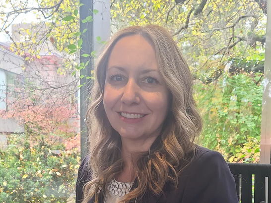 Melanie Brethour, wearing a black blazer in a professional photograph.